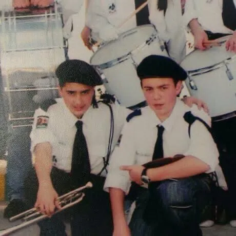 Majed in his school scout uniform holding a trumpet