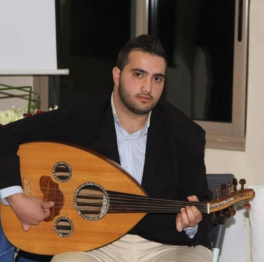 Majed performing with a traditional wooden oud