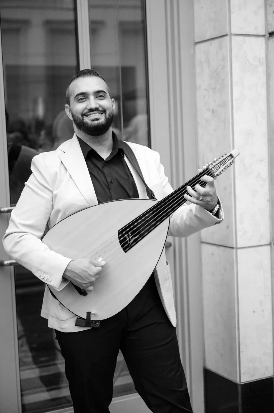 Majed in a white dinner jacket mid-performance