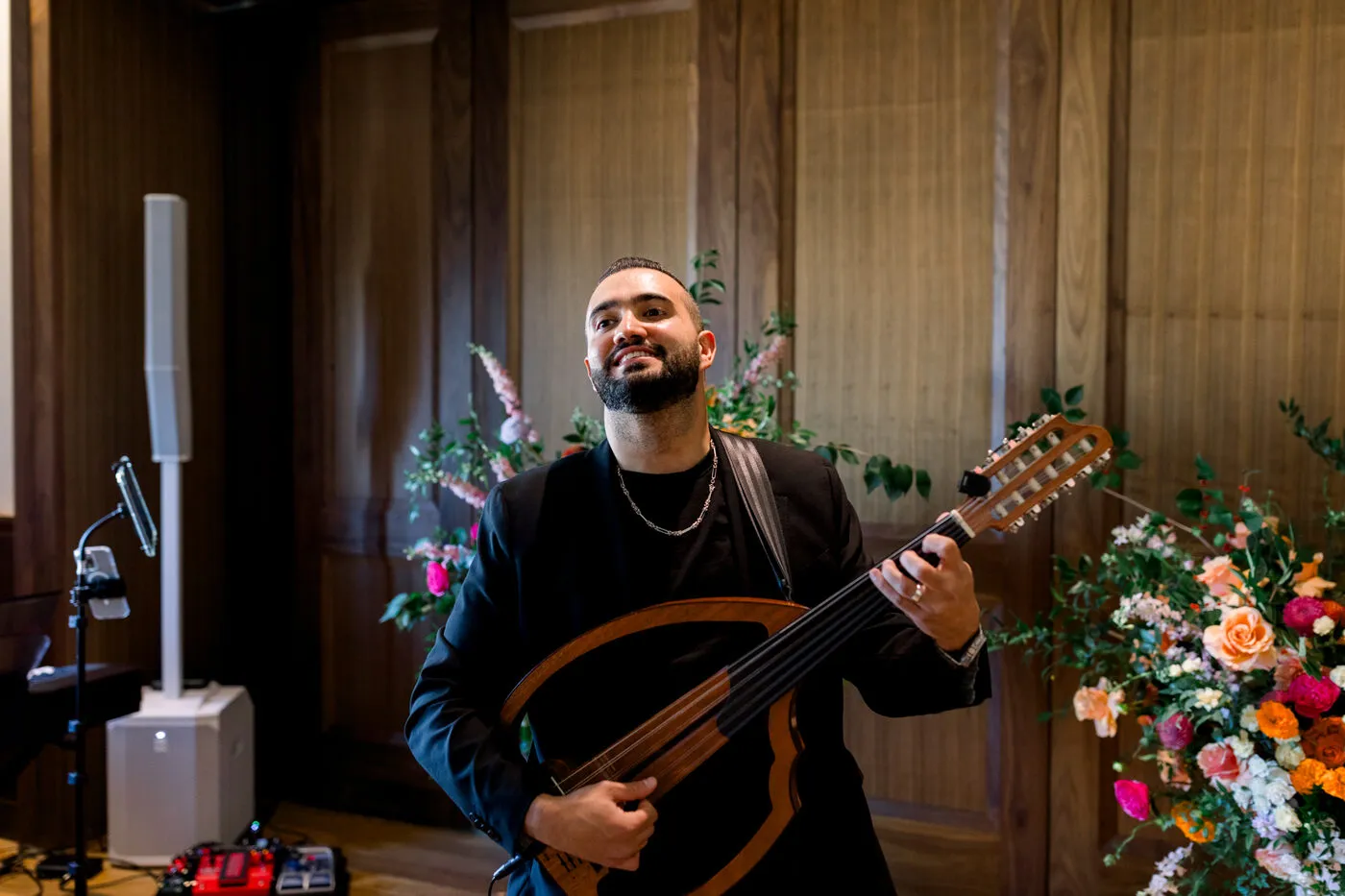Majed Chamseddine performing the oud beside a floral arrangement